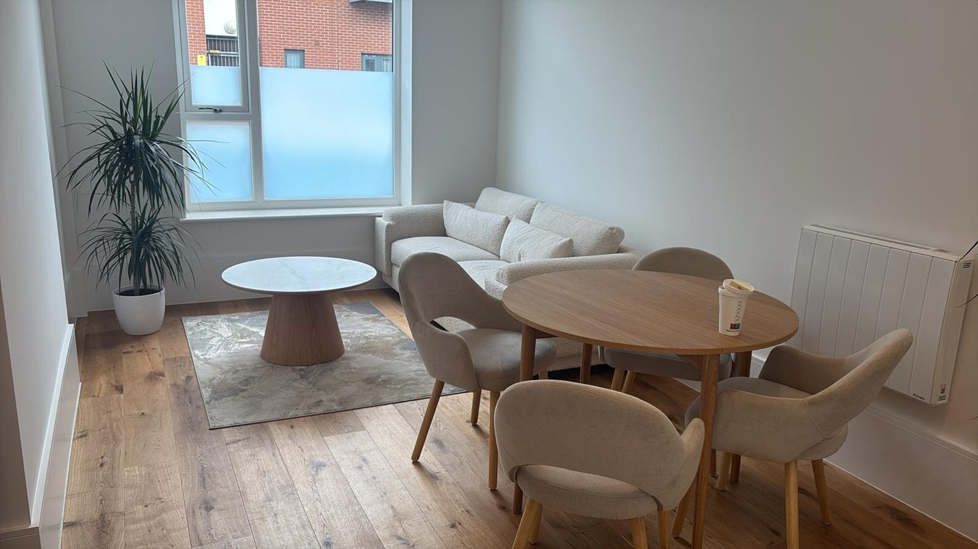 Finished apartment living area with sofa and dining table