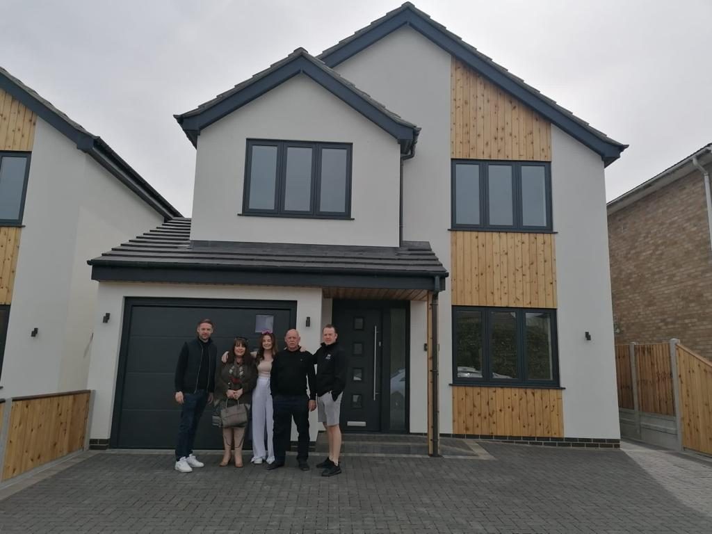 The James and Sons family outside a completed new build home