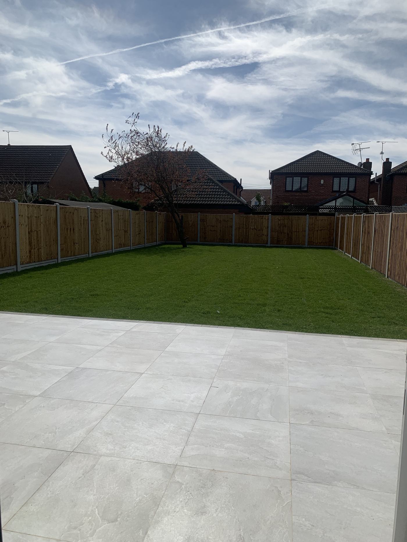 New turf and porcelain patio in a finished garden