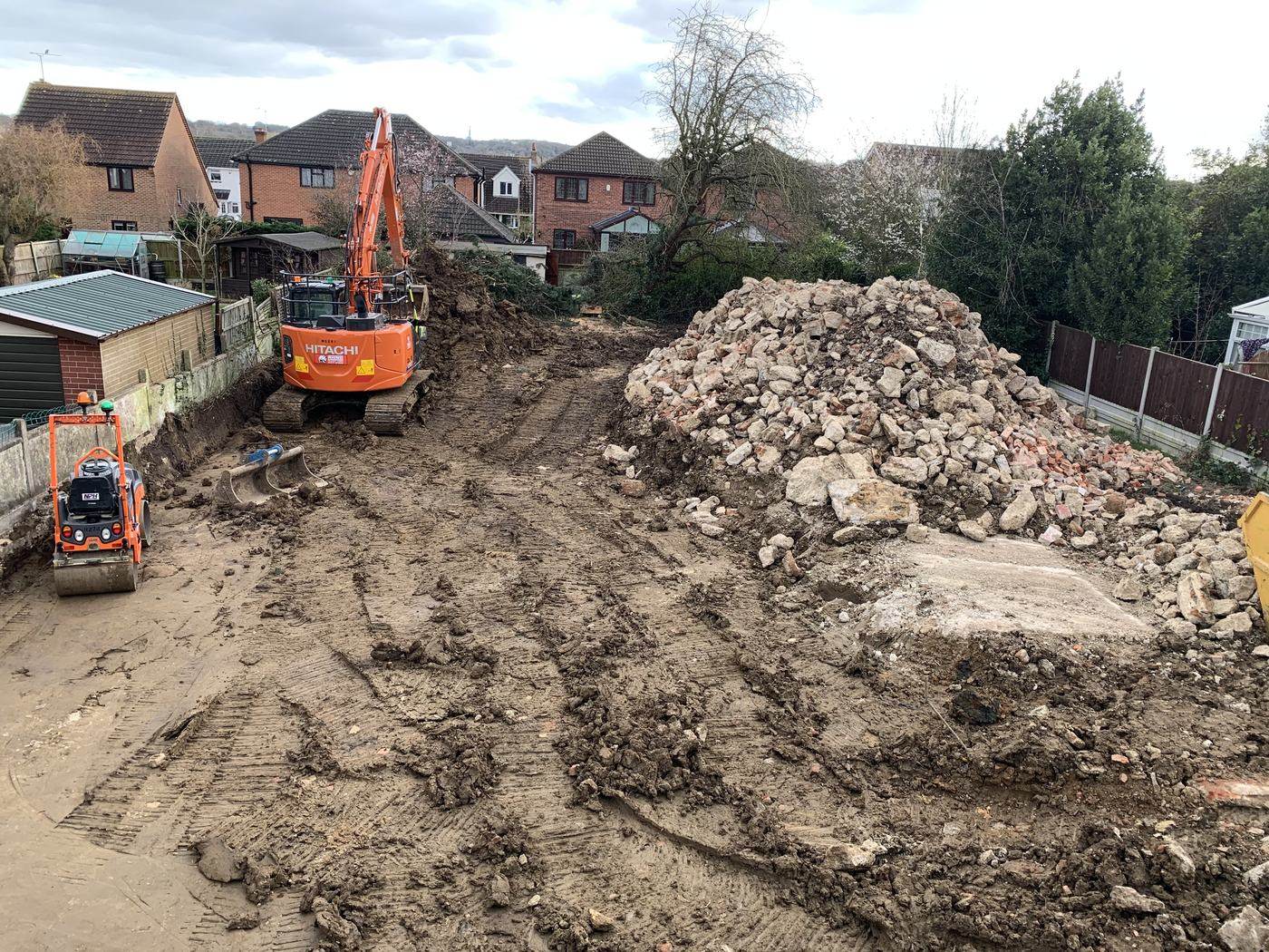 Digger clearing rubble on a site before construction