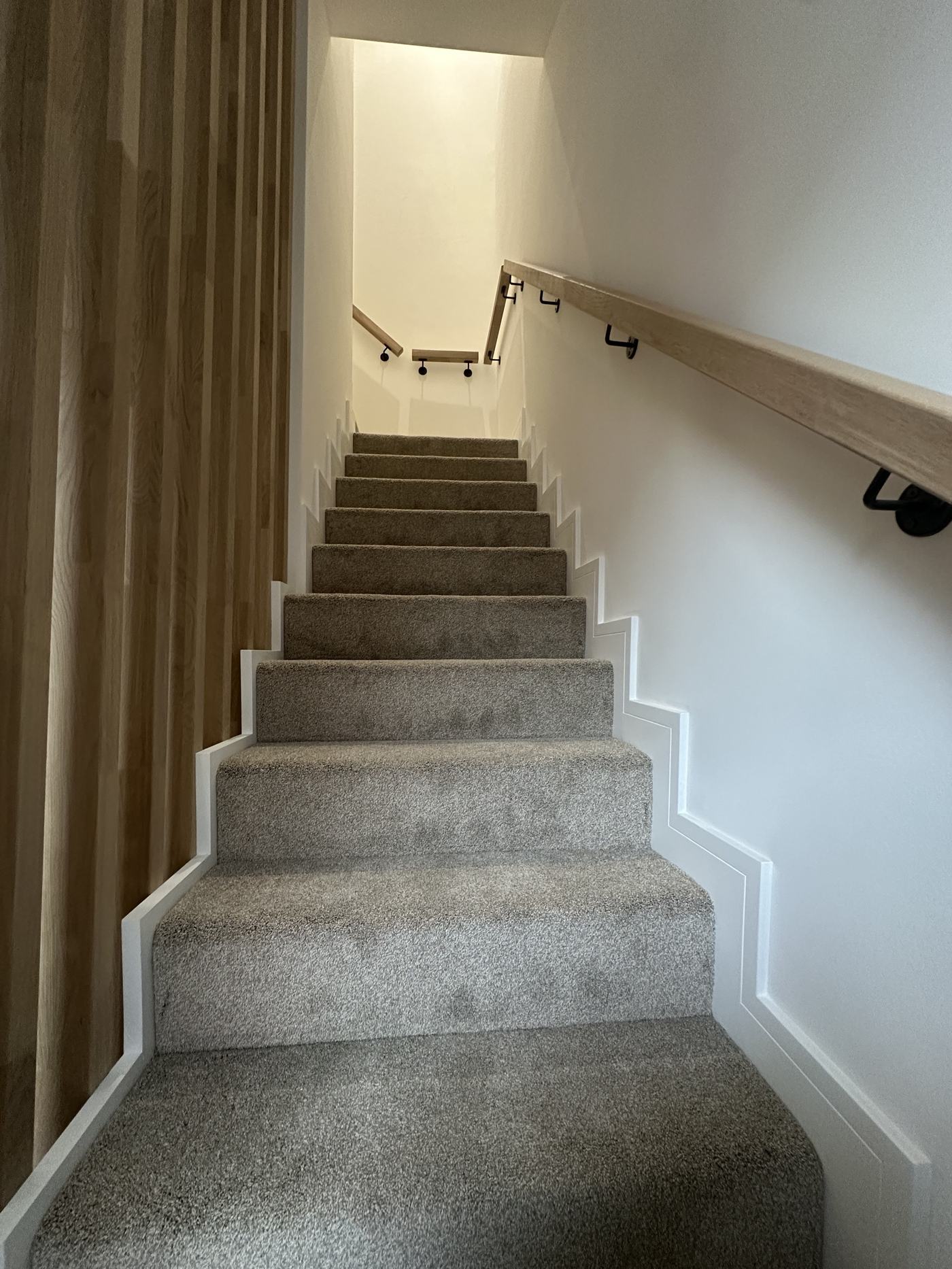 Finished carpeted staircase inside a home