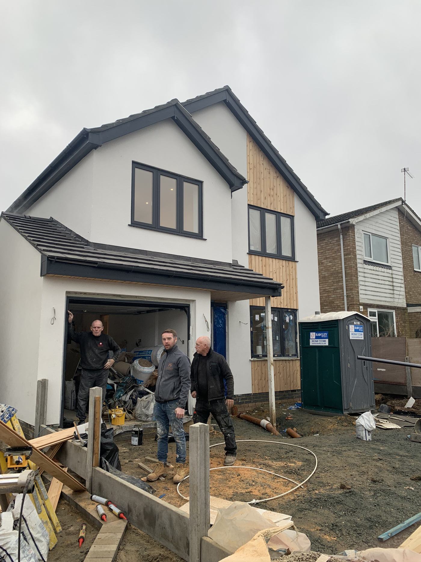Team members on site outside a new build home nearing completion